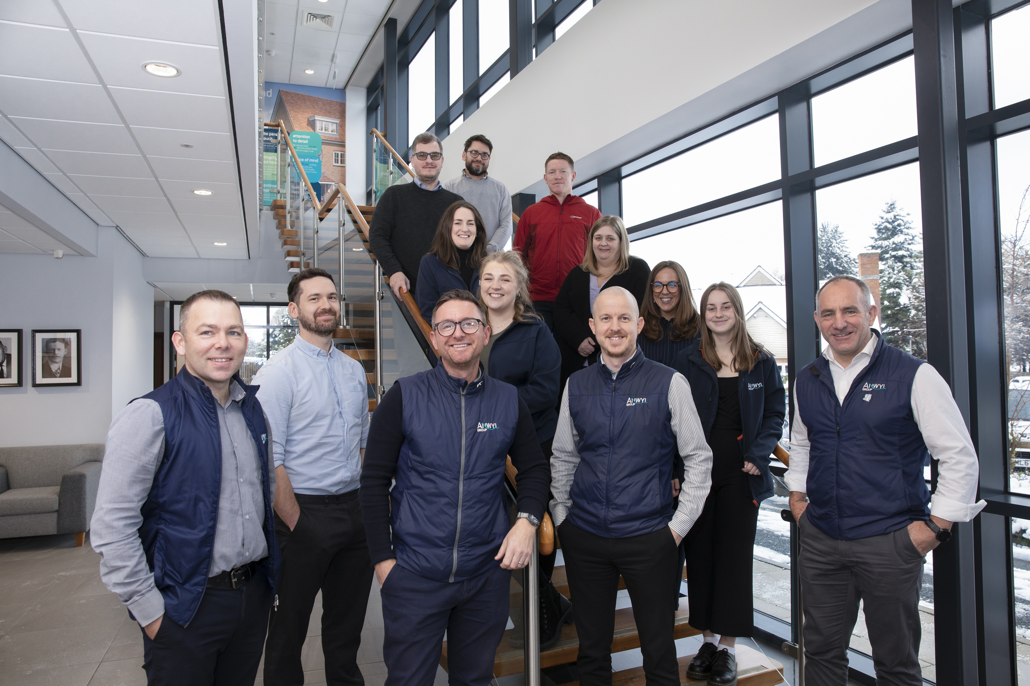 Group of Anwyl employees standing of staircase