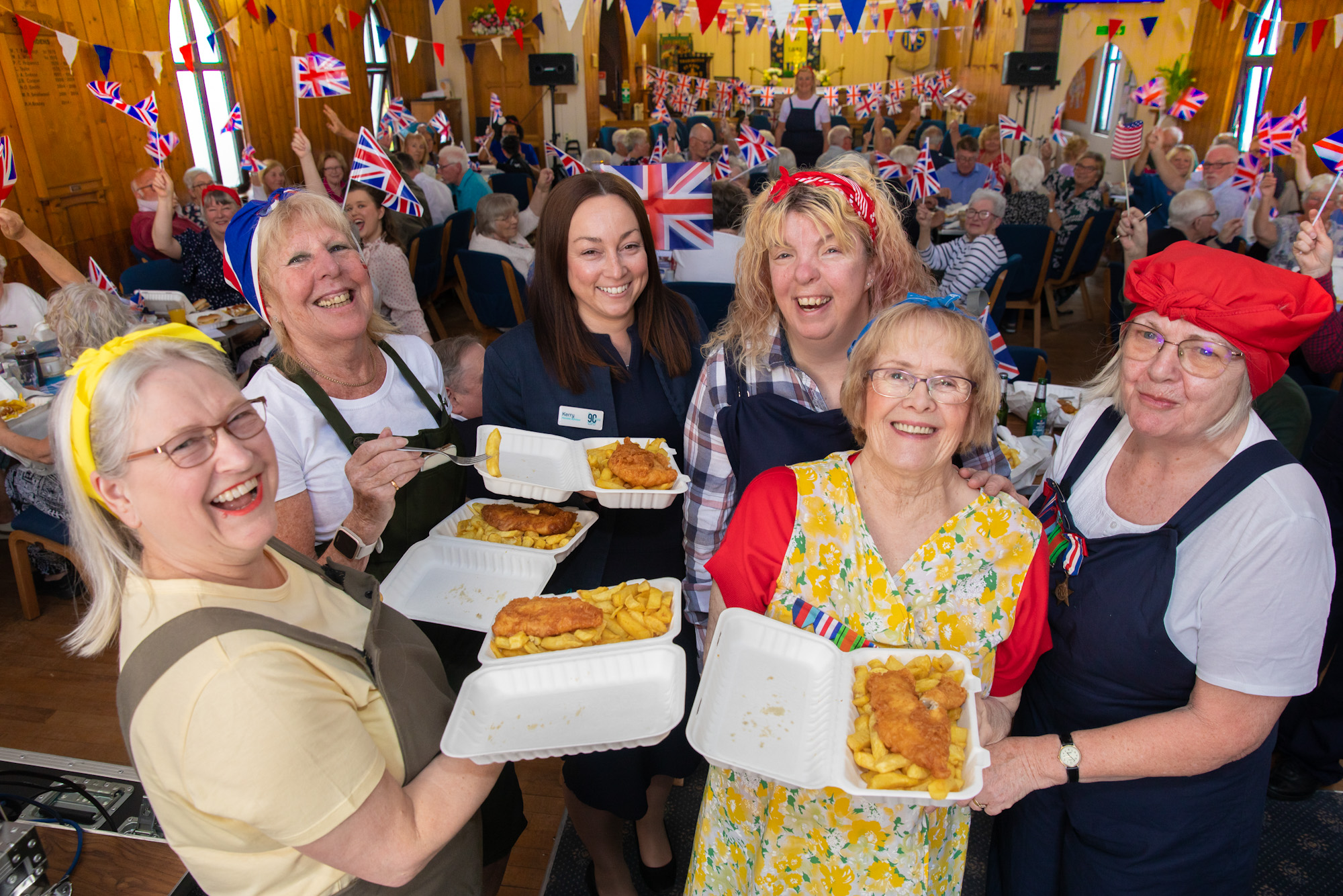 People celebrating VE day in their local Church enjoying fish and chips